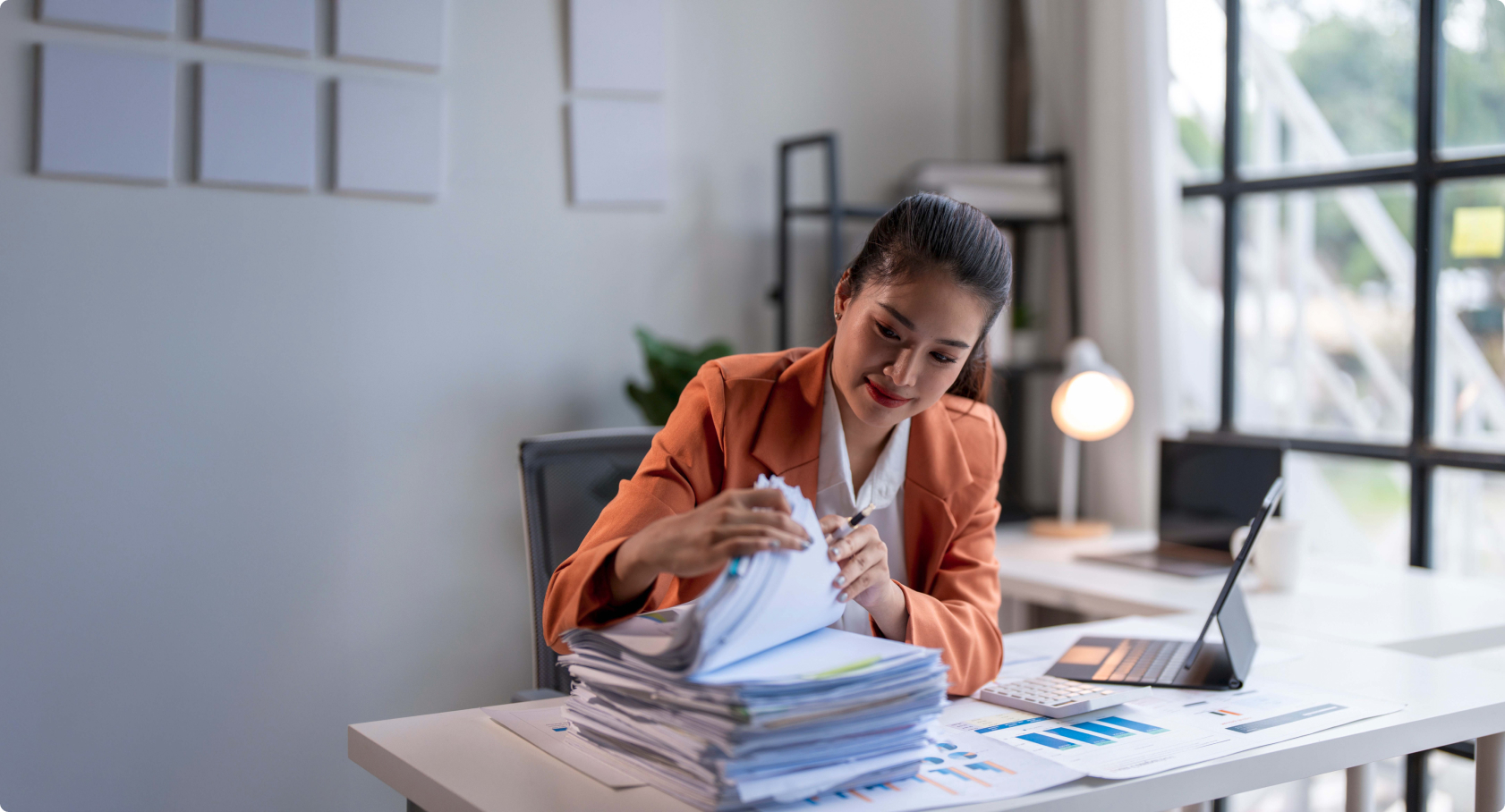 Woman sitting at desk looking through papers